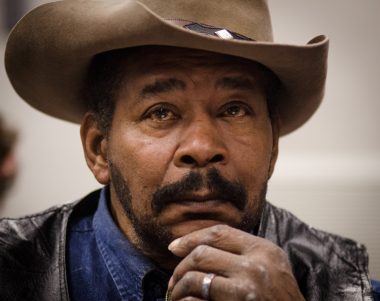 Close-up of a thoughtful Black man in a cowboy hat, reflecting on issues related to Black Studies.